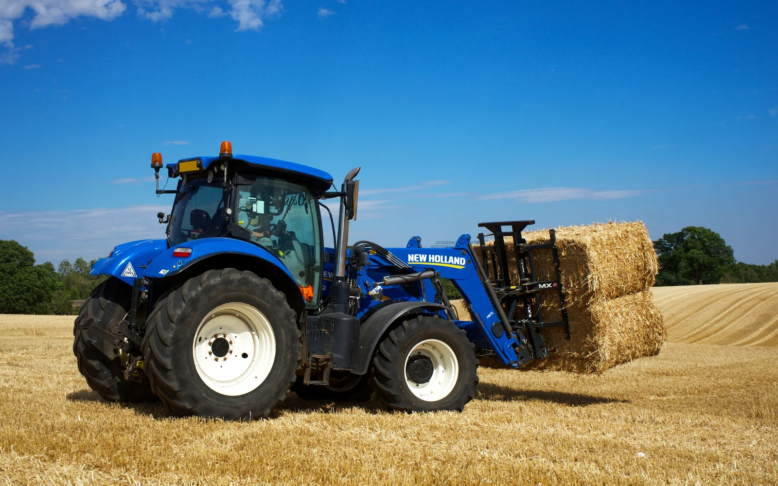 Modern blue agricultural tractor working in a field